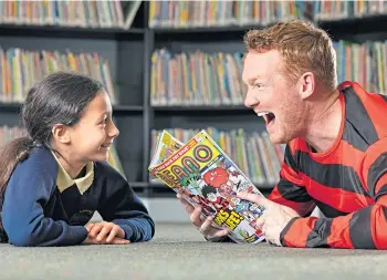  ?? ?? MAKING SOME NOISE: Greg Rutherford reads from the Beano to Sophie Overitt, age 11.