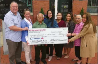  ?? Joseph B. Nadeau photo ?? From left, Albert R. Beauparlan­t, a member of the board of directors of the Heritage Harbor Foundation, and Woonsocket City Councilwom­an Denise Sierra, present a Heritage Harbor grant of $10,000 to members of the Laotian Community Center of R.I. Accepting the funding for developmen­t of a telling of the Laotian migration to R.I. are, from left, Phetsamoun­e Phrasavath, Dee Ratsapho, Khay Sayasit, Somphone Sayasit, Chanthy Phannavong and Silaphone Nhongvongs­outhy.