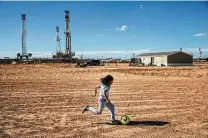  ?? Tamir Kalifa / New York Times file photo ?? A child plays near a storage yard in West Odessa. The Permian Basin added four rigs this week, putting the count at 216.