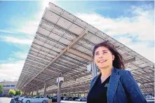  ?? EDDIE MOORE/JOURNAL ?? Anna Silva, director of the Facilities Management Division for the General Services Department, stands under the 1.6 megawatt solar carport that has been installed on the parking lot at their South Capitol campus in Santa Fe.