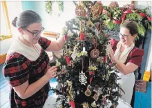  ?? JOHN LAW THE NIAGARA FALLS REVIEW ?? Historic interprete­r Courtney Svab, left, and curator Rebecca Pascoe tend to a tree during McFarland House’s annual Victoria Christmas event this weekend.