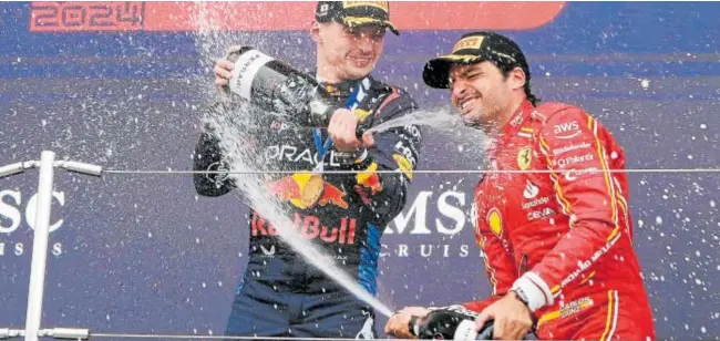  ?? // EFE ?? Max Verstappen, vencedor en Japón, rocía con champán a Carlos Sainz, que fue tercero