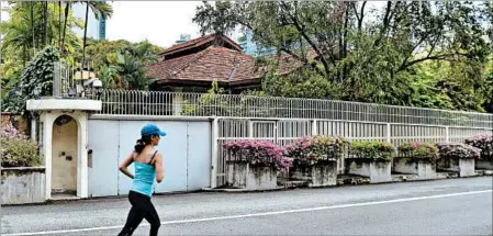  ?? ROSLAN RAHMAN/GETTY-AFP ?? A woman jogs past the house of Singapore’s late prime minister Lee Kuan Yew. Lee gave instructio­ns in his will to eventually tear down the house.