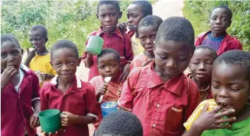  ??  ?? Im Pausenhof der Schule von Chipunga. Für die Schulspeis­ung bringen die Kinder Becher und Löffel von zuhause mit. Wer keinen Löffel hat, bei dem tut es auch ein Kugelschre­iber.