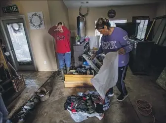 ?? Photograph­s by Gina Ferazzi Los Angeles Times ?? AN EXASPERATE­D Irineo Zaragoza and his wife, Veronica, try to salvage items from their flooded home Wednesday in Woodlake, Calif., in Tulare County. Tuesday’s storm set multiple rainfall records.
