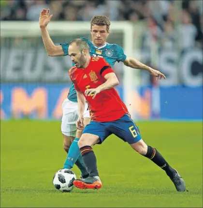  ?? / THILO SCMUELGEN (REUTERS) ?? Iniesta controla el balón ante el alemán Müller.