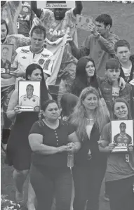  ?? EUROPEAN PRESS AGENCY ?? Relatives hold pictures of their loved ones at the memorial service for victims of a Nov. 28 plane crash.