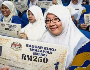  ??  ?? Happy recipients: Students with 1Malaysia Book Vouchers in this filepic.