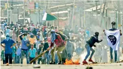  ?? — PTI ?? Mourners resort to stone pelting after clashes with the security forces on Saturday.