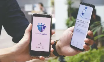  ?? — CATHERINE LAI/AFP ?? Singapore’s contact-tracing smartphone app and aggressive quarantini­ng helped the country control the spread of COVID-19 without a lockdown.