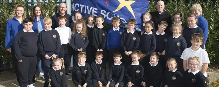  ??  ?? Teachers from the committee Ms Maguire and Ms McConn, Jim O’Riordan, Canon Sean Smith and Principal Carmel Dempsey with the students of the committee at the raising of the Active Flag at Newtownmou­ntkennedy Primary School.