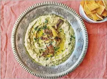  ??  ?? Grilled and marinated artichokes make quick work of this simple dip, enriched with tahini, cumin and lemon juice.