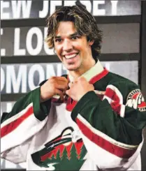  ?? JONATHAN HAYWARD/ CP ?? Benoit Pouliot of the Sudbury Wolves, one of the OHL’s marquee players, tries on a Wild jersey after Minnesota selected him in the first round of the NHL entry draft this summer.