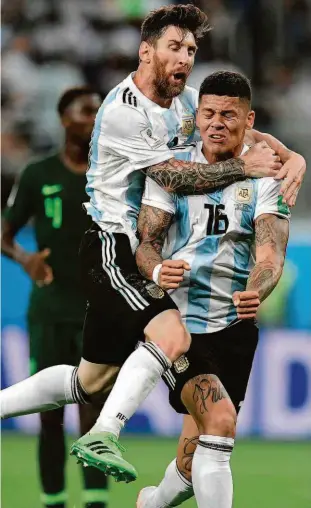  ?? Gabriel Bouys/afp ?? Messi salta sobre Rojo após o zagueiro marcar o gol da virada, aos 41min do segundo tempo, que deu a vitória e manteve a seleção argentina no Mundial
