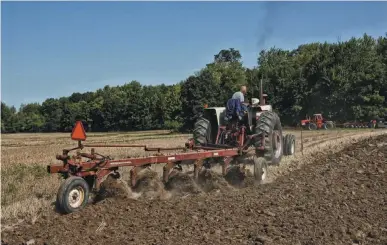  ??  ?? The 1206 was built to work, featuring a Cat III hitch. Don is pulling an IH
710 semi-mounted plow in hard, NW Ohio summer-baked clay and the tractor isn’t working very hard. Normally he carries six bottoms on the rack but anticipati­ng tough ground, he dropped a bottom for the Alvordton Plow Days but thought later it wasn’t necessary.