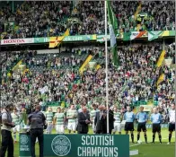  ??  ?? UP IN THE
AIR: Celtic fans and players may have to wait a few weeks longer than usual to see the league flag unfurled due to the 2014 Games