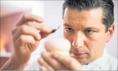  ??  ?? CREATIVE: Sebastian Kobelt carefully prepares one of his beautiful pâtisserie­s at his shop in Linlithgow. Picture Chris Watt