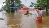  ?? — PTI ?? A devotee near the flooded Aluva Shiva Temple after heavy rains in Kochi on Friday. The entire district was put on red alert for extremely heavy rainfall.