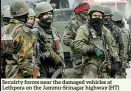  ??  ?? Secuirty forces near the damaged vehicles at Lethpora on the Jammu-srinagar highway (HT)