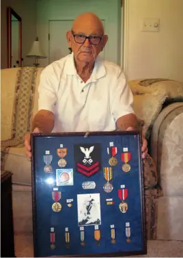  ?? Staff photo by Greg Bischof ?? ■ Texarkana, Texas, native George H. Ponder poses for a photograph with medals and other memorabili­a earned during World War II. Ponder, 91, served as a Navy signalman 2nd class in Pacific. He was aboard the USS John Penn when a Japanese torpedo plane...