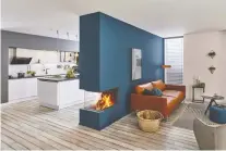  ??  ?? A colourful feature wall with built-in three-sided gas fireplace serves as an eye-catching decor feature and serves to divide the living area from the kitchen.