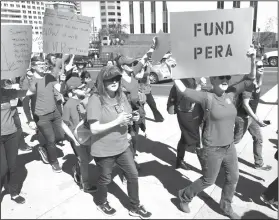  ?? AP Photo/David Zalubowski ?? Teachers: In this April 27, 2018, photograph, a teacher carries a placard in support of funding the teacher and other public sector workers' pension fund during a rally in Denver. Rising pension costs are eating away at teacher pay in Colorado and...