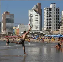  ??  ?? A MAN leaps for the ball during a game of paddle ball at the beach in Tel Aviv in July 2015.