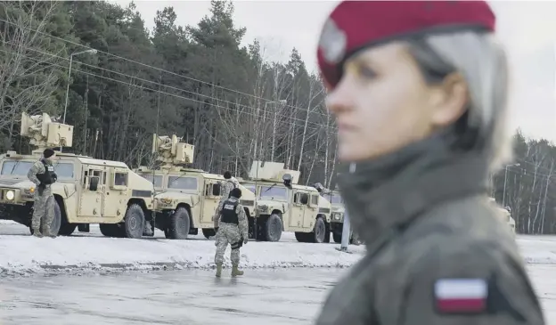  ?? PICTURE: NATALIA DOBRYSZYCK­A/AFP/GETTY IMAGES ?? 0 A Polish soldier looks on as US troops arrive in the country for deployment aimed at countering perceived Russian aggression