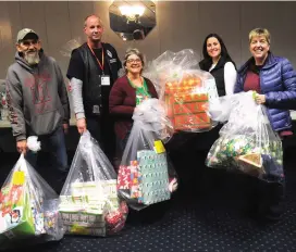  ?? Ernest A. Brown/The Call ?? Volunteers, from left, Kim Kaszyk, Rodney Lambert, Debbie Mitchell, Jen Seabury, and Lori Takalow get ready at the Elks Club in Woonsocket Thursday, before distributi­ng gifts and toys to some of the 951 Adopt-A-Families, which includes over 1,900...