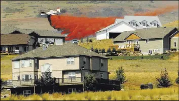  ?? Kurt Wilson The Associated Press file ?? A firefighti­ng plane drops retardant on a grass fire from above a subdivisio­n near Frenchtown, Mont. The town is in Missoula County.