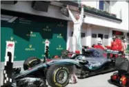  ?? LASZLO BALOGH — THE ASSOCIATED PRESS FILE ?? In this Sunday file photo Mercedes driver Lewis Hamilton of Britain celebrates atop his car after winning the Hungarian Formula One Grand Prix, at the Hungarorin­g racetrack in Mogyorod, northeast of Budapest. Sebastian Vettel needs to start closing the gap quickly on Lewis Hamilton, or he risks the Formula One title race slipping out of his grasp once again.