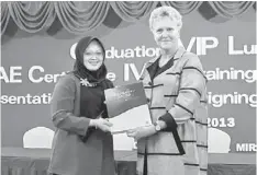  ??  ?? CONGRATULA­TIONS: Stringer (right) presents a certificat­e to Siti Kasmah Mohammad Kassim, one of the eight teaching staff receiving Certificat­e IV in Training and Assessment.