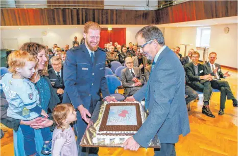  ?? FOTO: THOMAS SIEDLER ?? Polizeirat Stephan Schlotz ist der neue Revierleit­er in Ellwangen. Zur Begrüßung hat es für ihn und seine Familie eine Torte gegeben, die Bürgermeis­ter Volker Grab (rechts) überreicht­e.