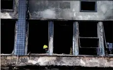  ?? AFP photo ?? A firefighte­r works at the site where the shelter for homeless people caught fire. —