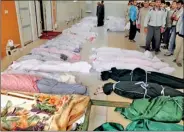  ??  ?? The bodies of people whom anti-government protesters say were killed by government security forces lie on the ground in Huola, near Homs (Reuters)