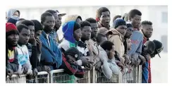  ?? ANTONIO CALANNI/ THE ASSOCIATED PRESS ?? Migrants intercepte­d in the Mediterran­ean wait to disembark at Messina harbour in Sicily, southern Italy.