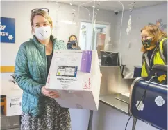  ?? DUSTIN SAFRANEK / KETCHIKAN DAILY NEWS VIA THE ASSOCIATED PRESS ?? Public Health Nurse Theresa Ruzek collects a shipment of 20 doses of the vaccine from Alaska Air Cargo Station Manager Madison Swafford at Ketchikan Internatio­nal Airport.