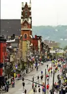  ??  ?? Pittsburgh Marathon runners make their way along Liberty Avenue in May 2009 past Immaculate Conception-St. Joseph Parish in the city’s Bloomfield neighborho­od.