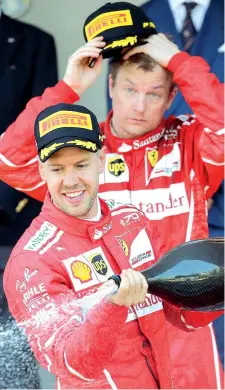  ??  ?? Brindisi Vettel sul podio con lo champagne. Alle sue spalle, Raikkonen (Reuters)