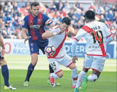  ??  ?? PELEA. El capitán oscense Carlos David lucha por un balón con el delantero rayista Javi Guerra.