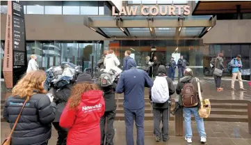  ?? — AFP photo ?? Journalist­s gather outside the Christchur­ch District Court as Tarrant appeared for his hearing via audio-visual link from a maximum-security prison in Auckland.