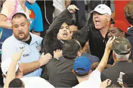  ?? Brynn Anderson / Associated Press ?? A man is removed as he protests Republican presidenti­al candidate Donald Trump during a campaign rally on Saturday in Orlando, Fla. Security experts say Trump should show more tolerance for protest and not stir up the crowd.