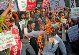  ?? — BIPLAB BANERJEE ?? Activists raise slogans as they burn the effigy of Haryana CM Manohar Lal Khattar during a protest at Haryana Bhavan in New Delhi on Wednesday.