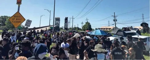  ?? MARIA CLARK/USA TODAY NETWORK AND GETTY IMAGES ?? A crowd gathers at the Belle Chasse bridge in Louisiana on June 12 to protest racial injustice.