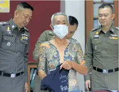  ?? THE ASSOCIATED PRESS ?? Japanese gang member Shigeharu Shirai displays his tattoos at a police station during a press conference in Lopburi, central Thailand, on Thursday. Shirai is accused of killing a rival gang member in Japan 15 years ago.