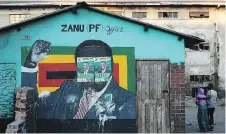  ?? DAN KITWOOD/GETTY IMAGES ?? Election posters in support of Zimbabwean President Emmerson Mnangagwa are pasted over a mural of former president Robert Mugabe in Harare. Mnangagwa hopes illegal wildcat gold mining now widespread in the country will boost the economy.