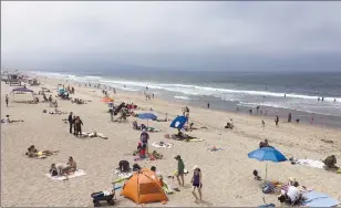  ?? Associated Press ?? People enjoy the weather in Manhattan Beach on Sunday. Skies cleared intermitte­ntly and then a steady onshore breeze kept the marine layer pressed against the shoreline. Almost all of inland California was predicted to simmer this week at above normal...