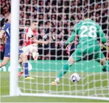  ?? GETTY ?? Leandro Trossard di sinistro supera il portiere Djordje Petrovic e dopo 4' sblocca il risultato all'Emirates Stadium portando in vantaggio l'Arsenal sul Chelsea I Blues chiuderann­o la serata con 5 gol al passivo