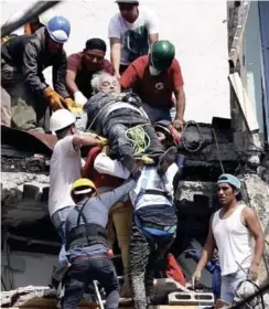  ?? AP ?? Ayuda. Rescatista­s bajan a una persona que en principio quedó atrapada entre los escombros del edificio donde residía y que resultó dañado por el sismo.