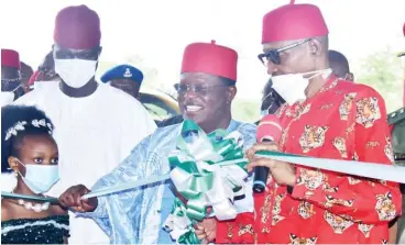  ?? Photo: NAN ?? President Muhammadu Buhari (R), cutting tape to inaugurate the Dualised Enugu-UburuAbaka­liki Federal Road reconstruc­ted by Ebonyi State Government, during his 2-Day official visit to Ebonyi State yesterday. With him is Gov. Dave Umeahi of Ebonyi State (R) and Speaker, Ebonyi State House of Assembly, Mr Francis Nwaifuru.